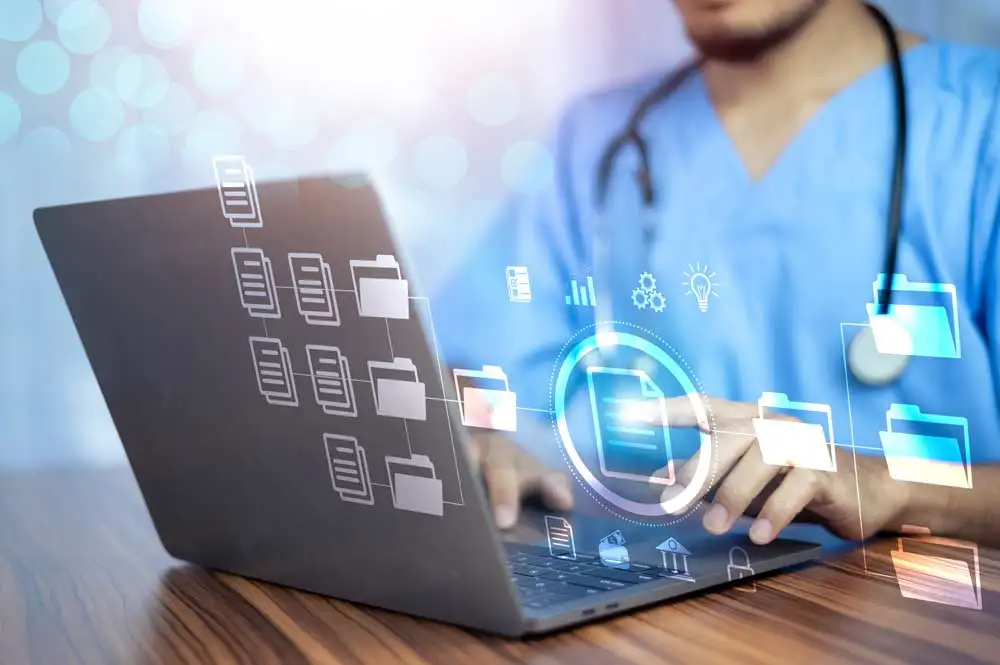 Healthcare professionals managing patient data through electronic health records on desktop screens, guided by knowledge management for healthcare systems